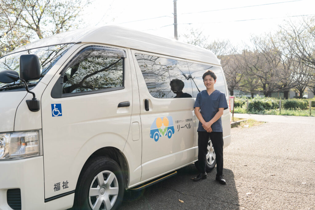 介護タクシーの車両とリーベルのスタッフ